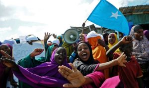 Demonstrators hold placards during a protest against Al shabab insurgents outside Lido beach in the Somali capital Mogadishu, on January 28, 2016. Al Shebab killed at least 19 people when five gunmen detonated a bomb before storming a restaurant in the at Lido beach on January 22, 2016.  / AFP / MOHAMED ABDIWAHAB        (Photo credit should read MOHAMED ABDIWAHAB/AFP/Getty Images)