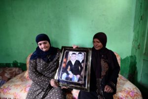Meseda Abdel-Wahab (R), mother of teenager Fares Ezzat, and his aunt Halawethorn Abdel-Wahad pose holding a photograph of him at the family home in the village of Meit Massoud in Aga, Egypt, November 16, 2016. REUTERS/Stringer